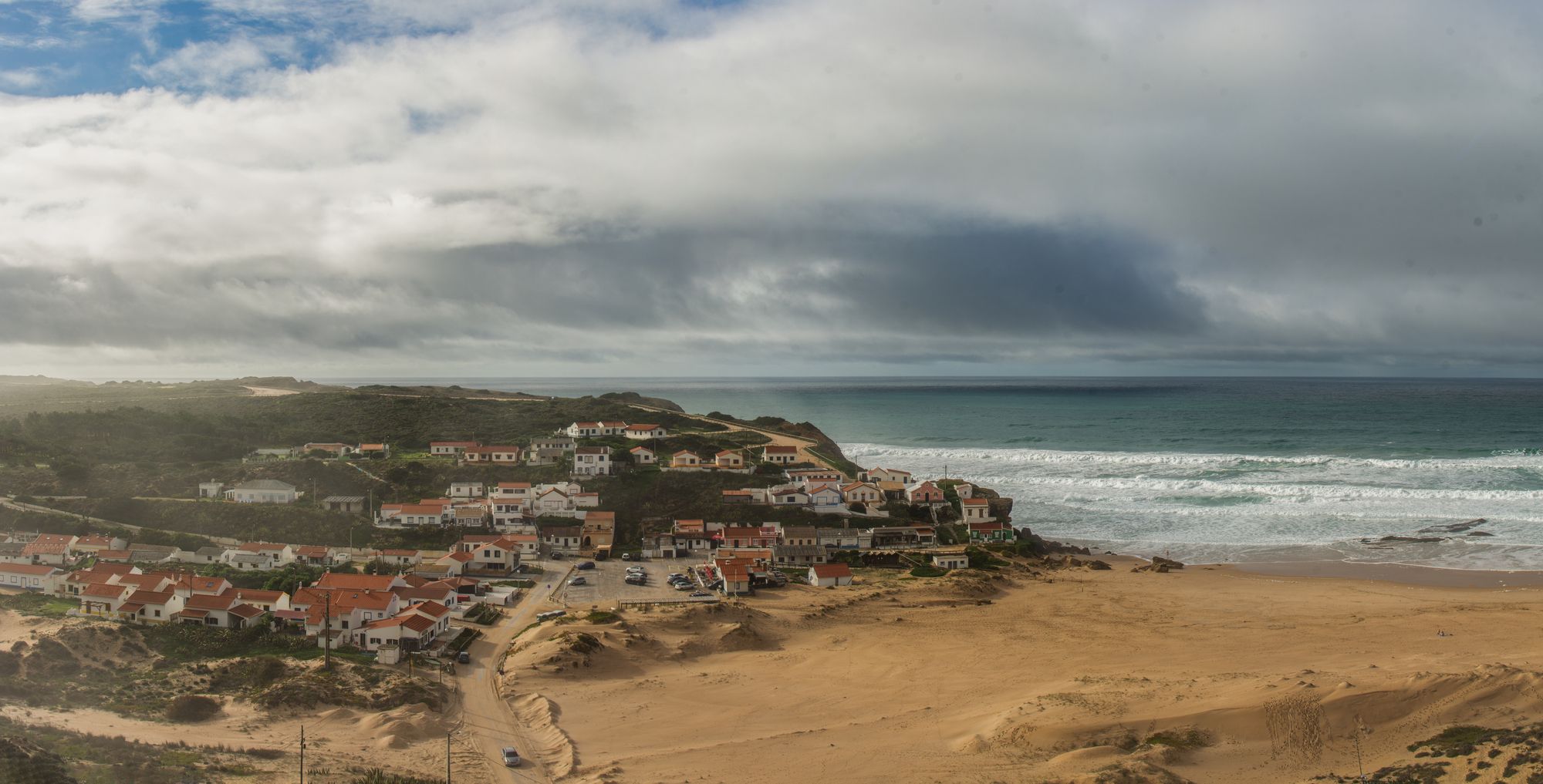 a beach with houses and a body of water